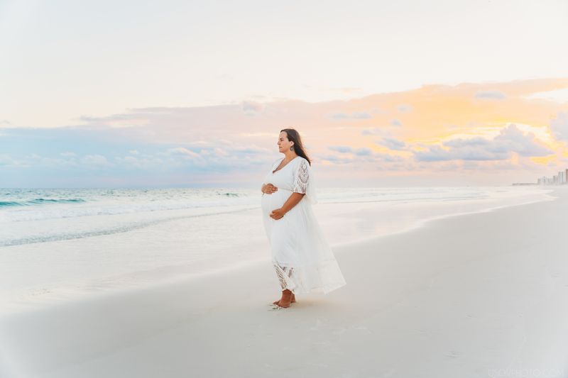 Maternity photoshoot in Destin, mother-to-be at a beach with sunset in background