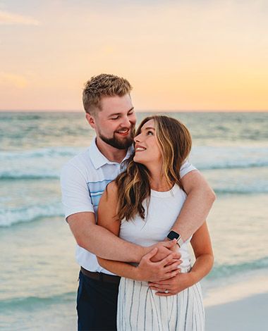 couple hugging and looking at each other, sunset time on a beach