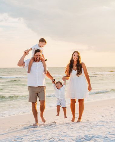 family of 4 having fun on a beach sunset time photoshoot